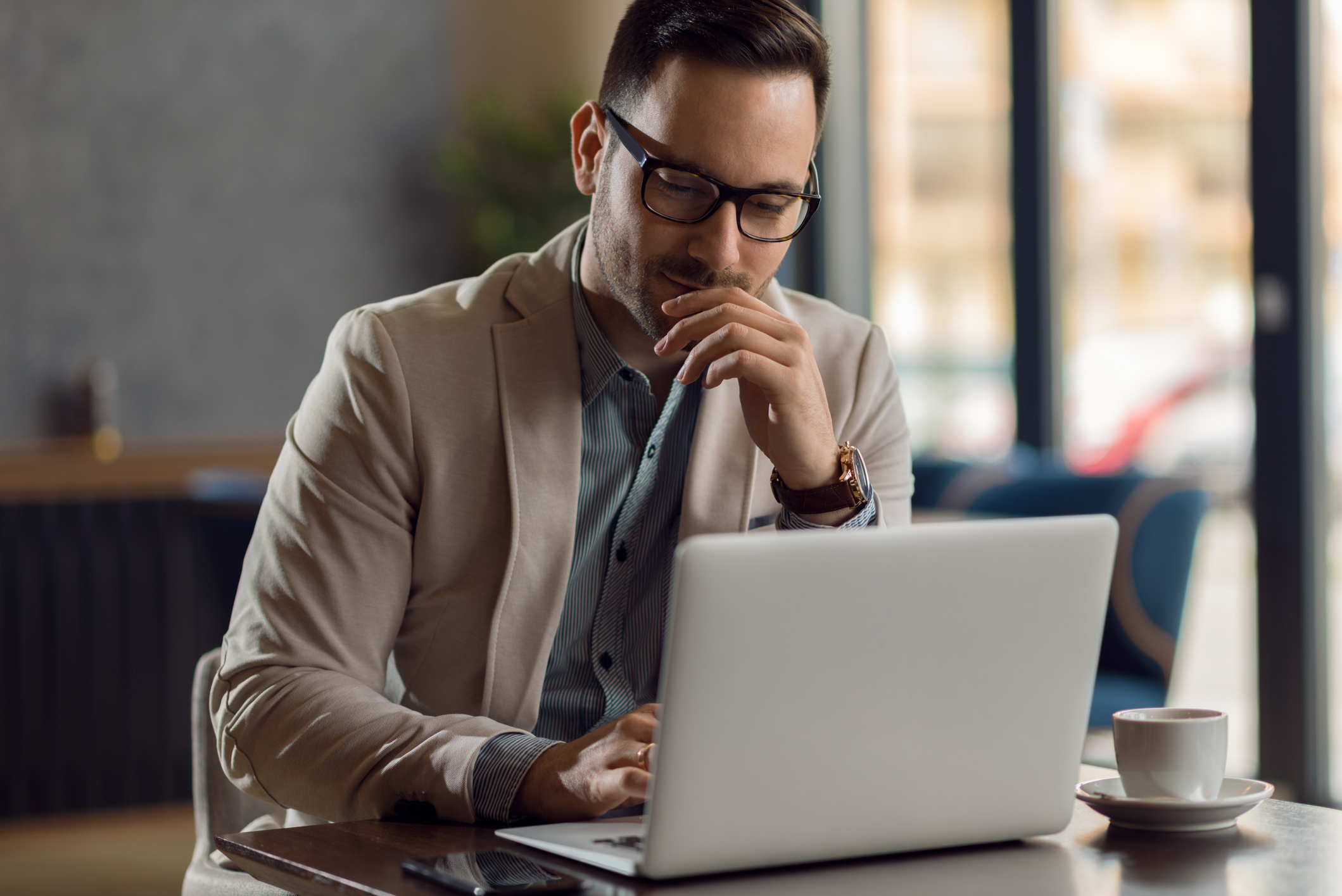 Young businessman using laptop in a cafe