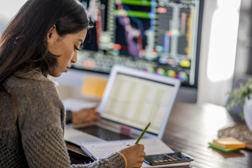 Young business woman day trading from her dining room table