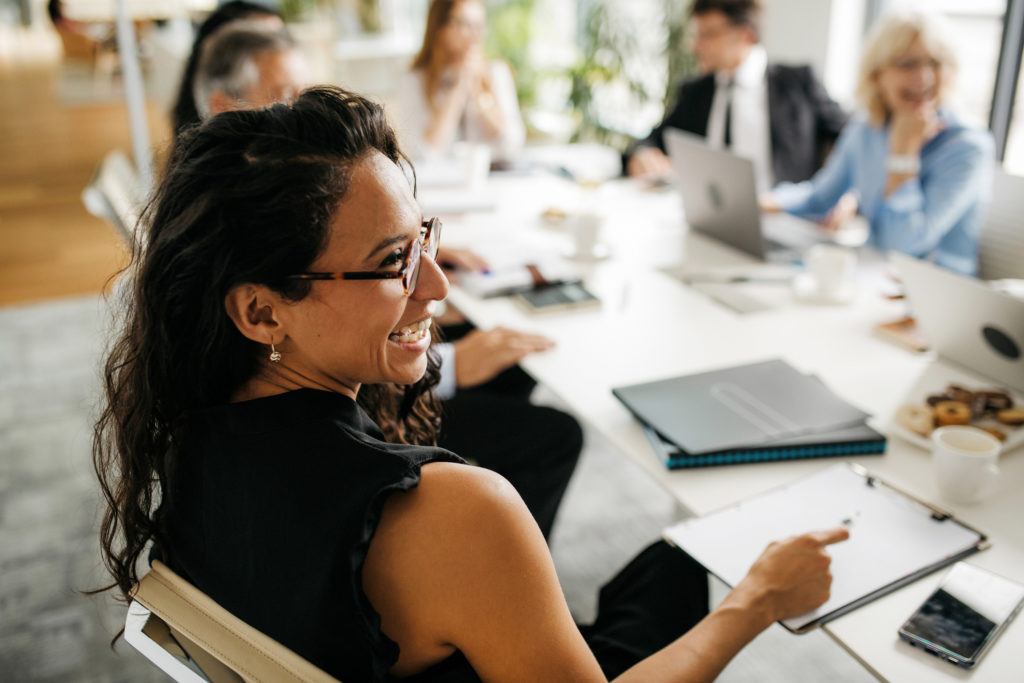 Businesswoman sitting at a desk laughing